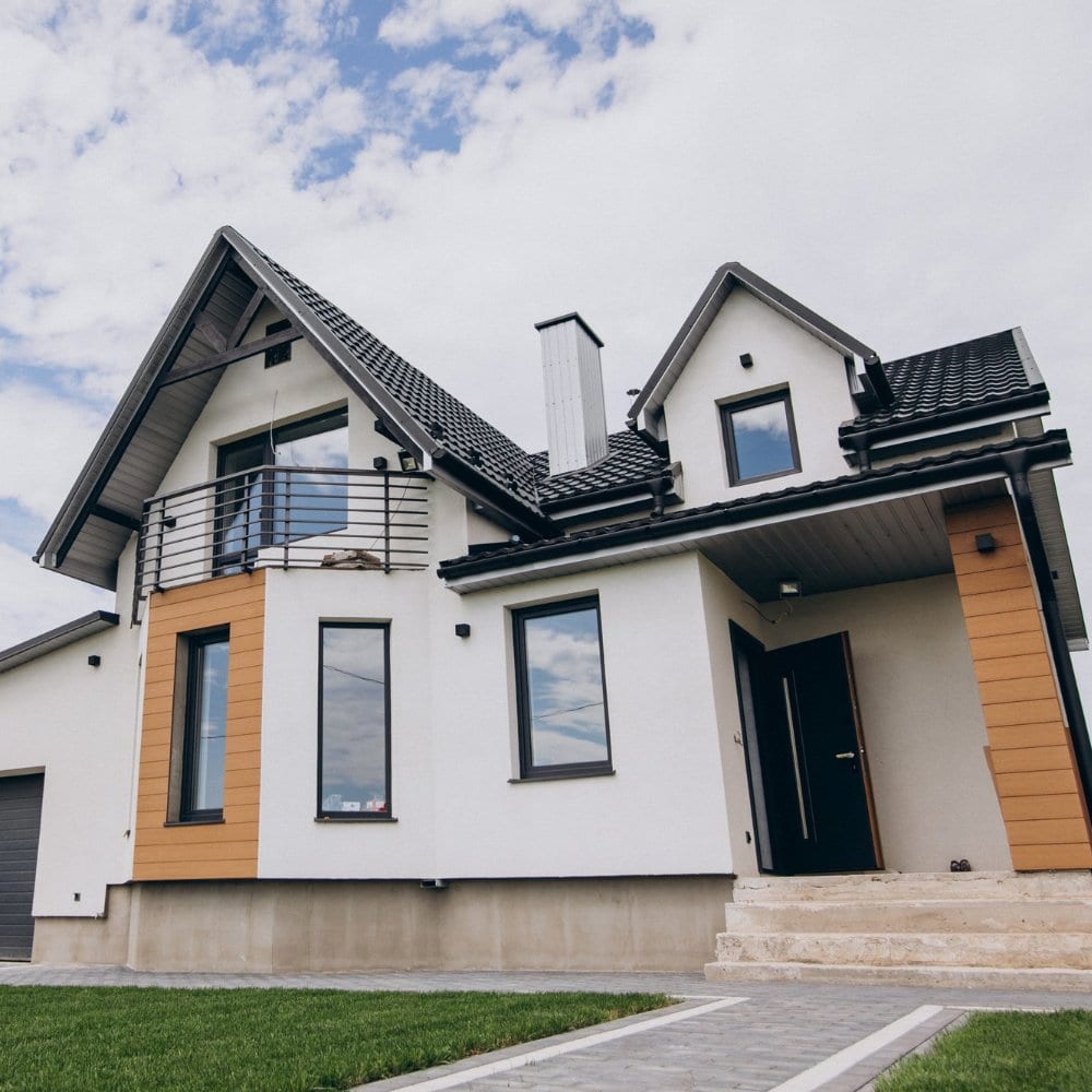 Modern white house with dark roof tiles and timber cladding