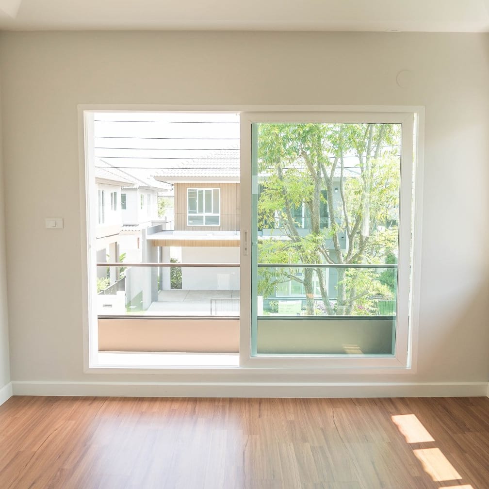Newly built empty room with wood floor and a large sliding window