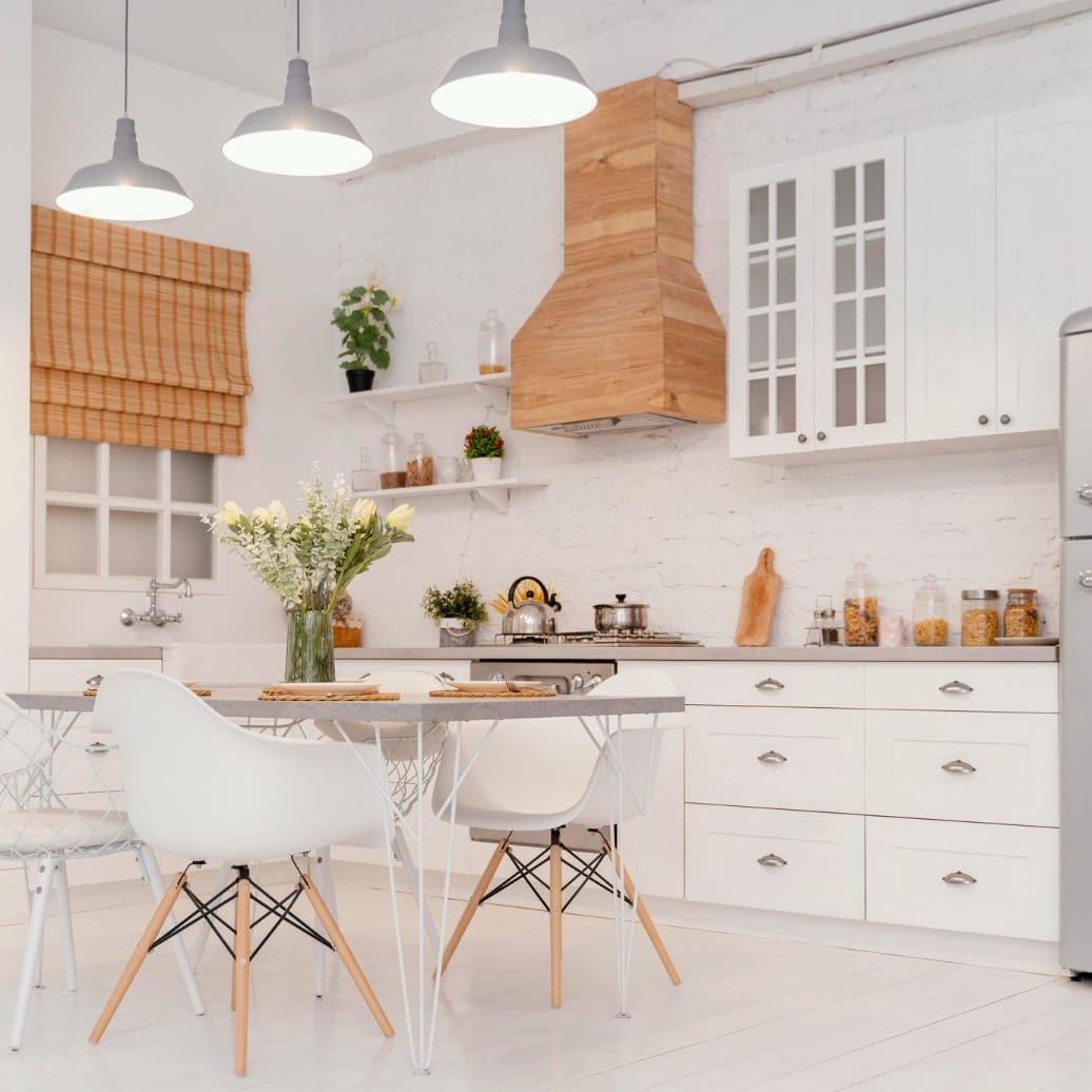 White kitchen with a timber extractor hood and a small dining table